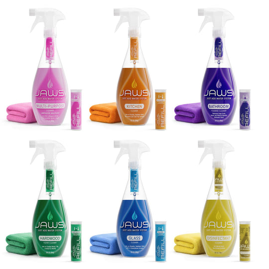 Collection of six JAWS cleaning products with bottles, microfiber clothes and refill pods on a white background.  Pink, Orange, Purple, green Blue and Yellow (Multi-purpose, Kitchen, Bathroom, Floor, Glass and Disinfectant cleaners).