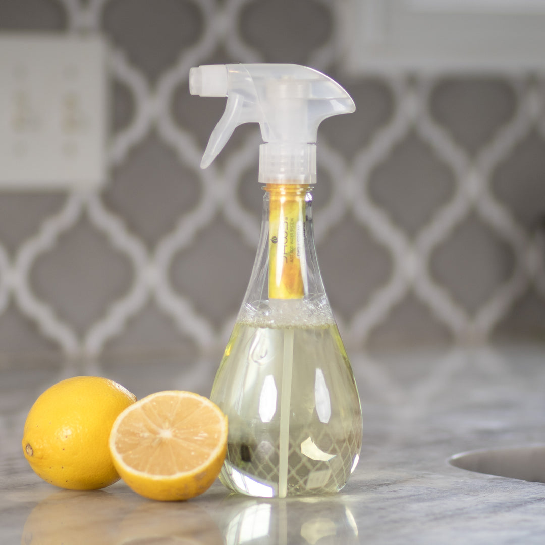 JAWS Dish Spray Cleaner with lemons next to it on a kitchen counter.