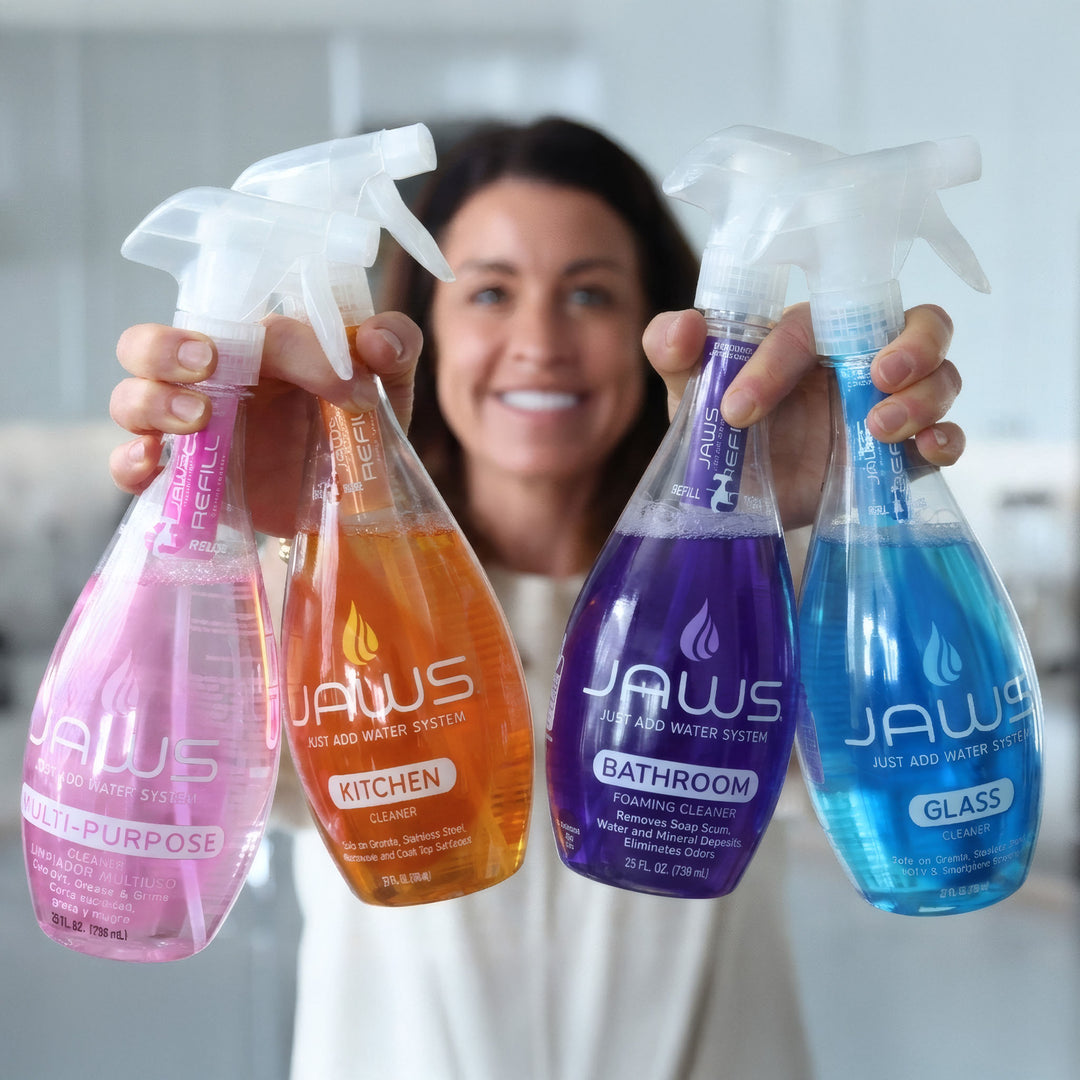 Woman holding four bottles of JAWS cleaning products in different colors.