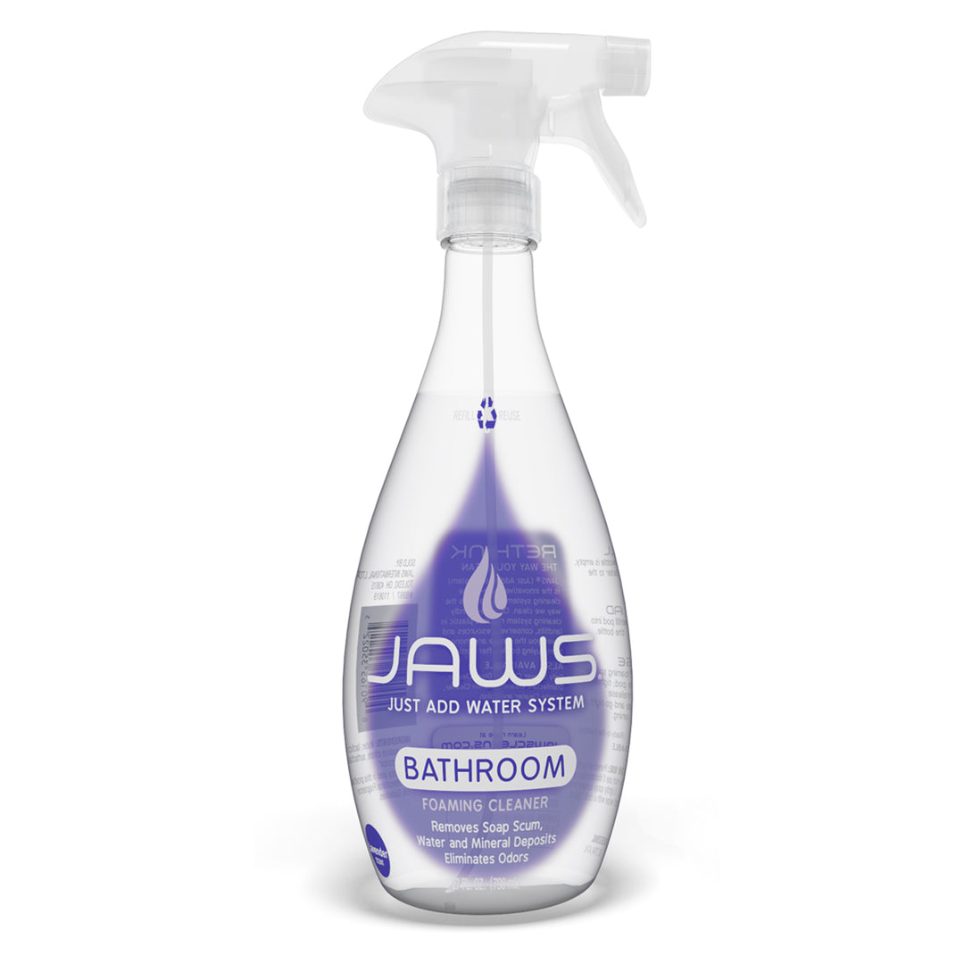 An empty bottle of Jaws Foaming Bathroom Cleaner on a white background. The bottle is clear plastic with a white trigger spray top and features a purple label with the brand name 'JAWS' and 'BATHROOM' printed on it.