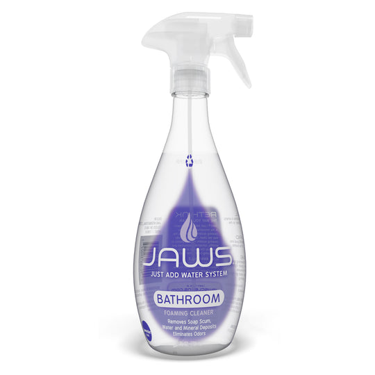 An empty bottle of Jaws Foaming Bathroom Cleaner on a white background. The bottle is clear plastic with a white trigger spray top and features a purple label with the brand name 'JAWS' and 'BATHROOM' printed on it.