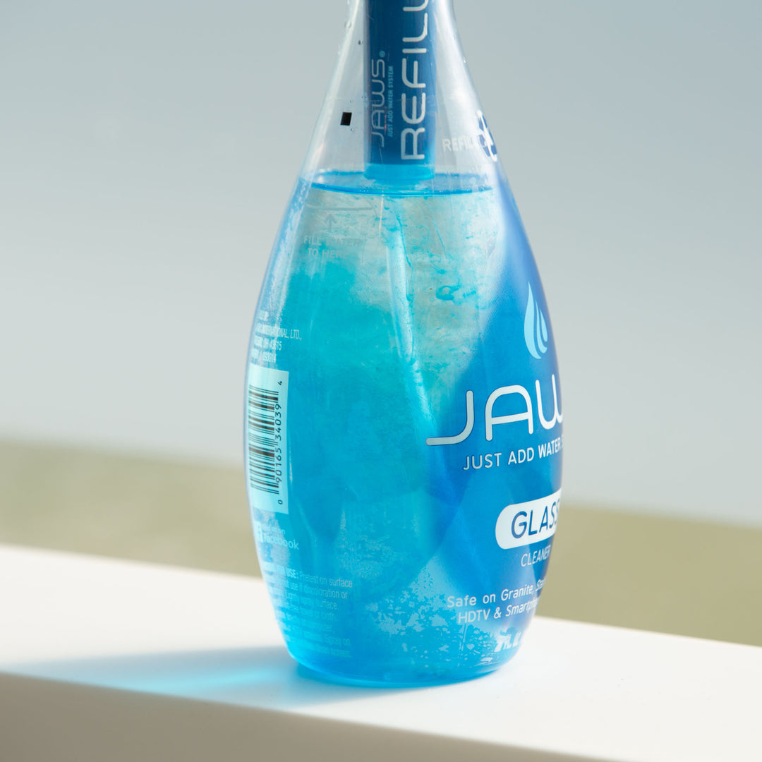 Blue JAWS Glass Cleaner bottle with refill concentrate releasing into the water.