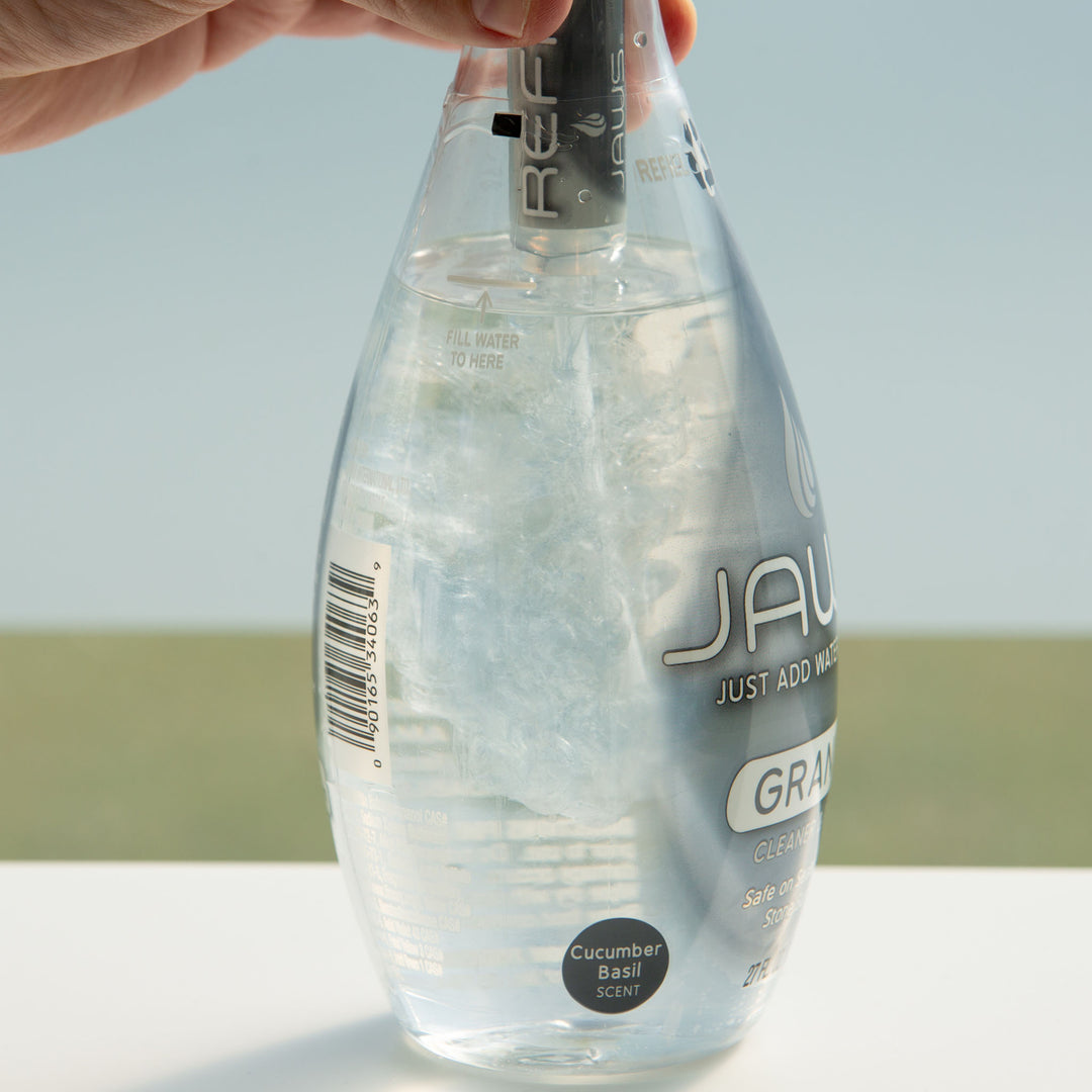 JAWS Granite Cleaner Bottle with refill pod releasing concentrate into bottle.