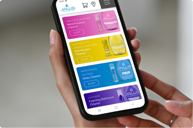 Hand holding a smartphone displaying an app interface with colorful product images.