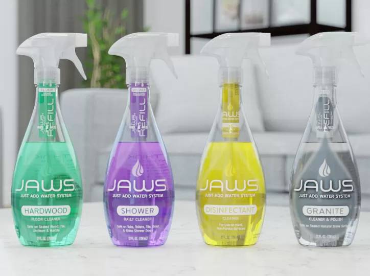 Four JAWS cleaning product bottles on a white surface with a blurred background (Hardwood, Shower, Disinfectant, Granite)