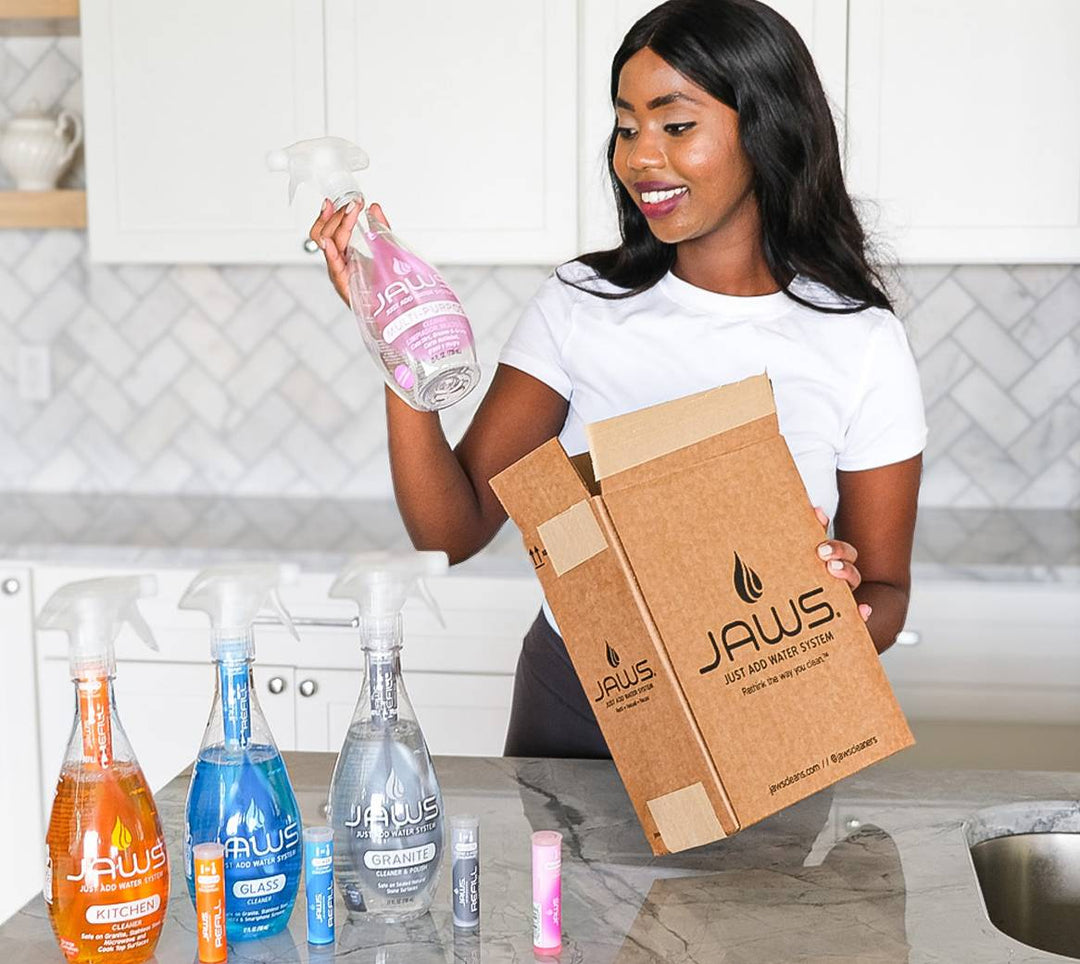 Woman holding a JAWS  bottle and box in a kitchen