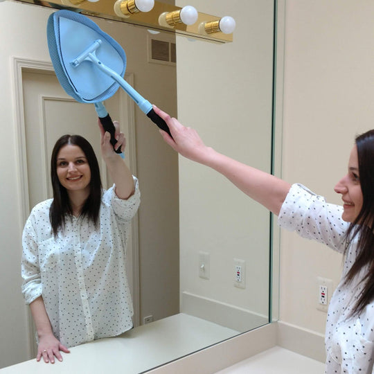 Woman cleaning bathroom mirror with JAWS cleaning wand